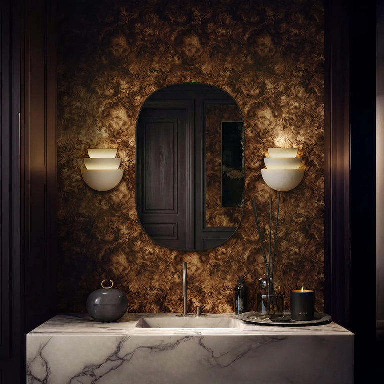 Lemieux et Cie Heirloom Walnut Burl Wood peel and stick wallpaper with warm brown tones and swirling organic grain, shown in a moody powder room.
