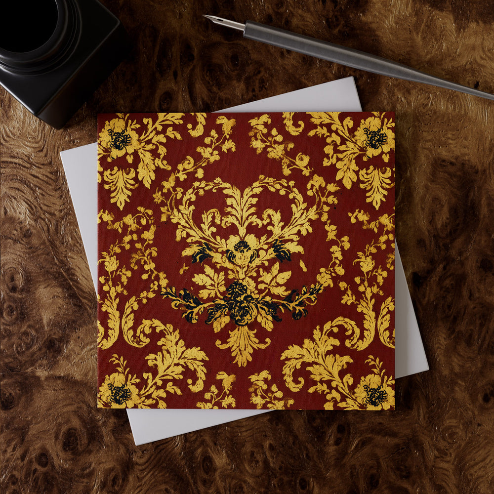 Lemieux et Cie Holiday Damask Greeting Card Set in vermilion with gold floral motif, luxury stationery shown on figured wood surface with white envelope and pen.