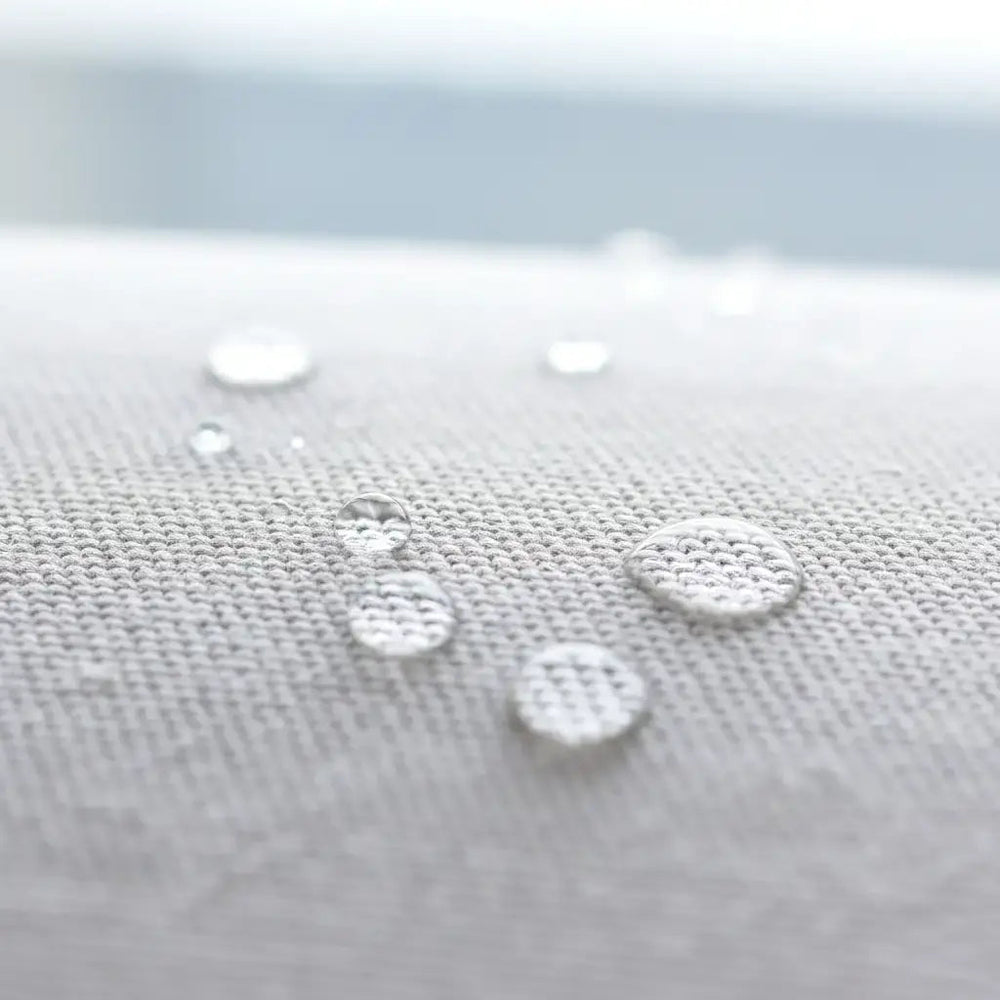 Lemieux et Cie Hudson Chaise Lounge Outdoor Cover, water-resistant textile with beaded droplets in close-up, soft neutral daylight in background.