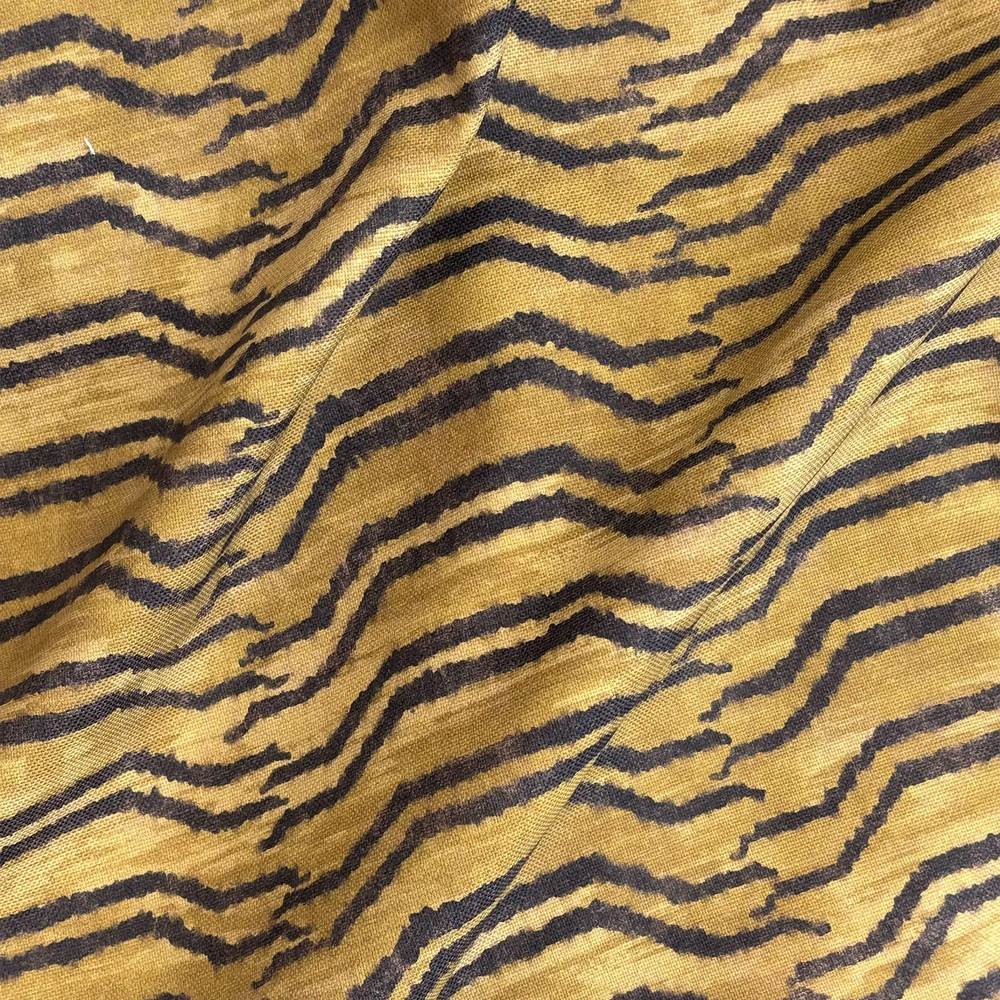 Lemieux et Cie Tiger Stripe Outdoor Pillow in golden yellow and charcoal, woven stripe pattern shown draped on textured surface.