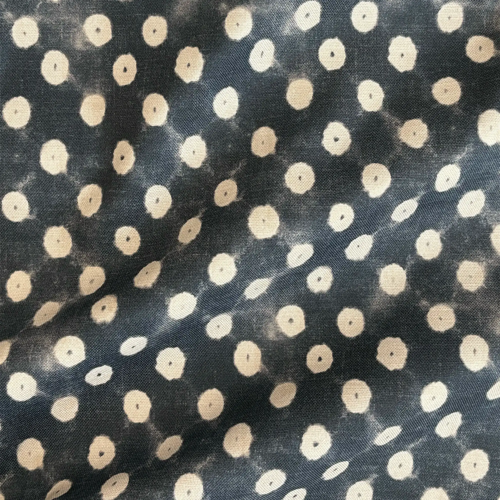 Lemieux et Cie Outdoor Pillow in Indigo Resist Dye Polka Dot, cushion with irregular ivory dots on deep charcoal ground, shown in close detail view.