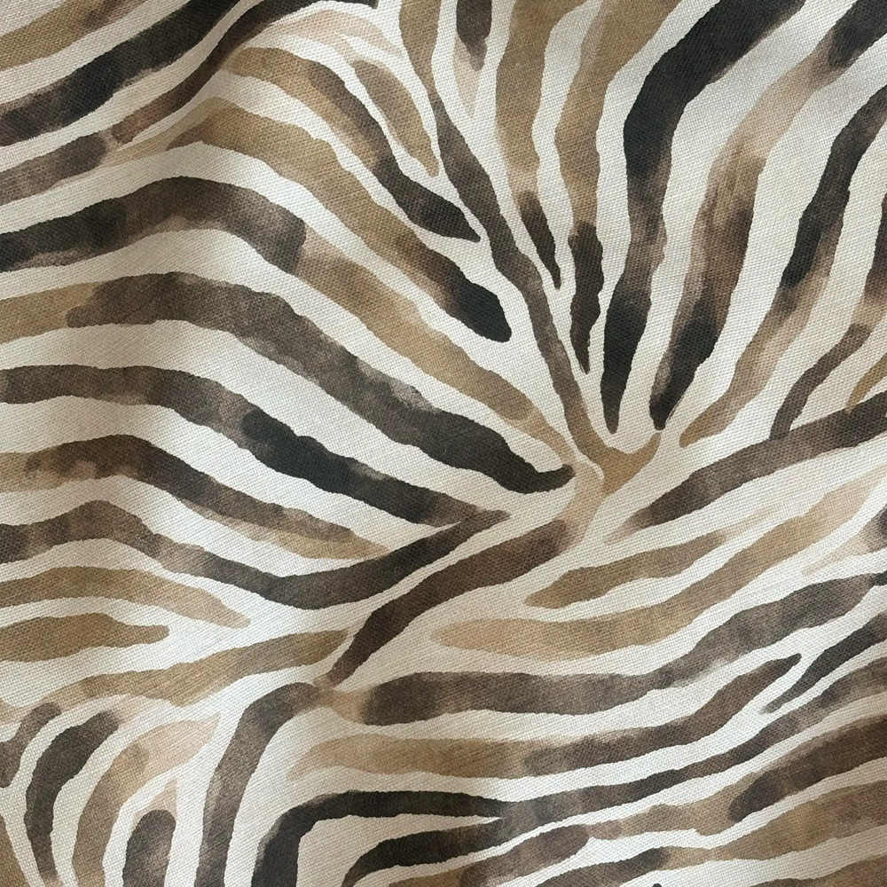 Lemieux et Cie Outdoor Pillow in Safari Zebra, neutral and charcoal zebra stripe pattern on woven textile, close detail of draped form.