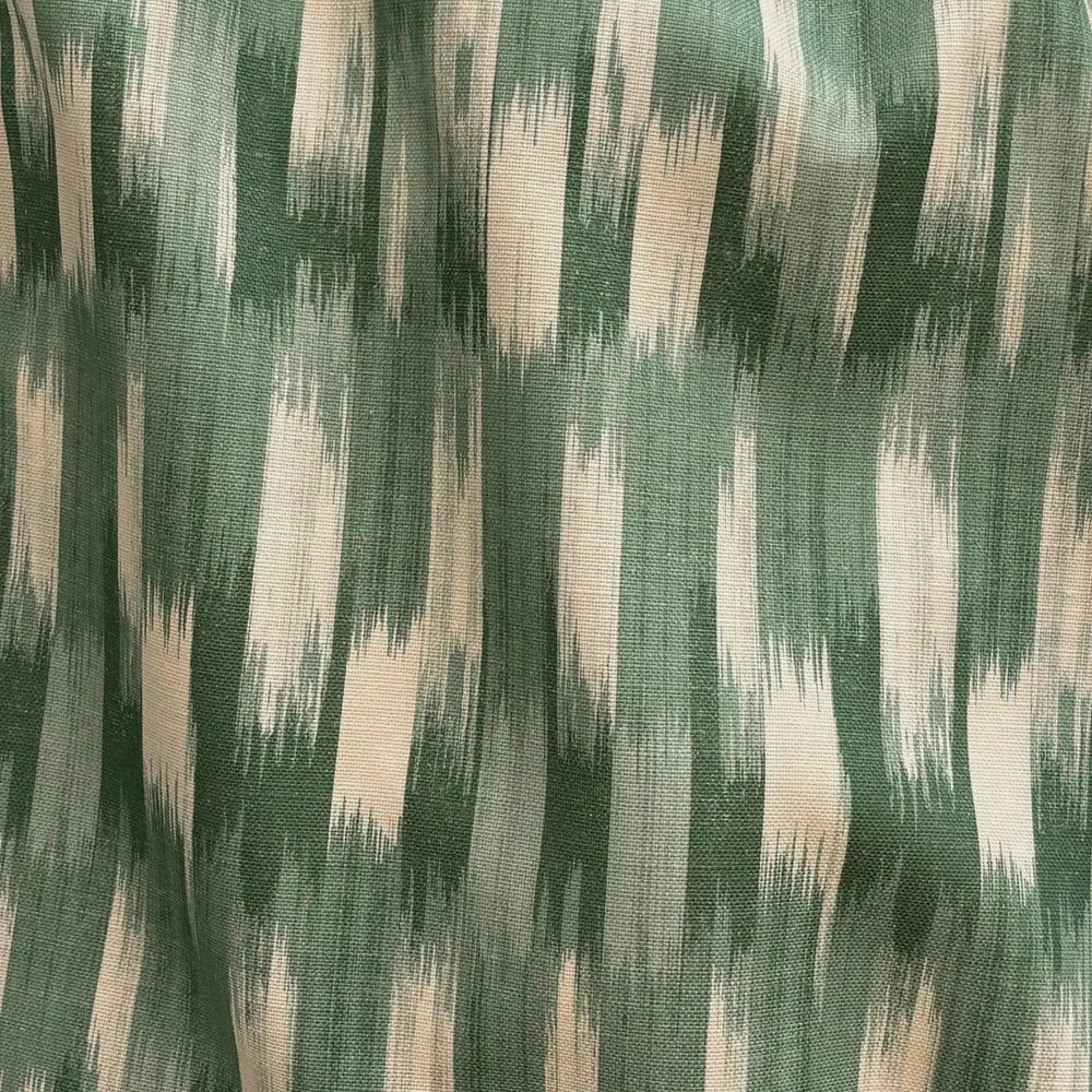 Lemieux et Cie Outdoor Pillow in Green French Flamme, ikat-patterned throw pillow with feathered green and cream stripes, draped detail shot