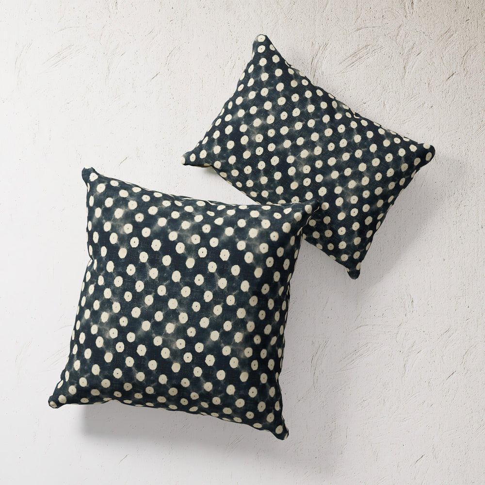 Lemieux et Cie Outdoor Pillow in indigo with cream polka dot pattern, square throw pillows shown on textured white plaster wall.