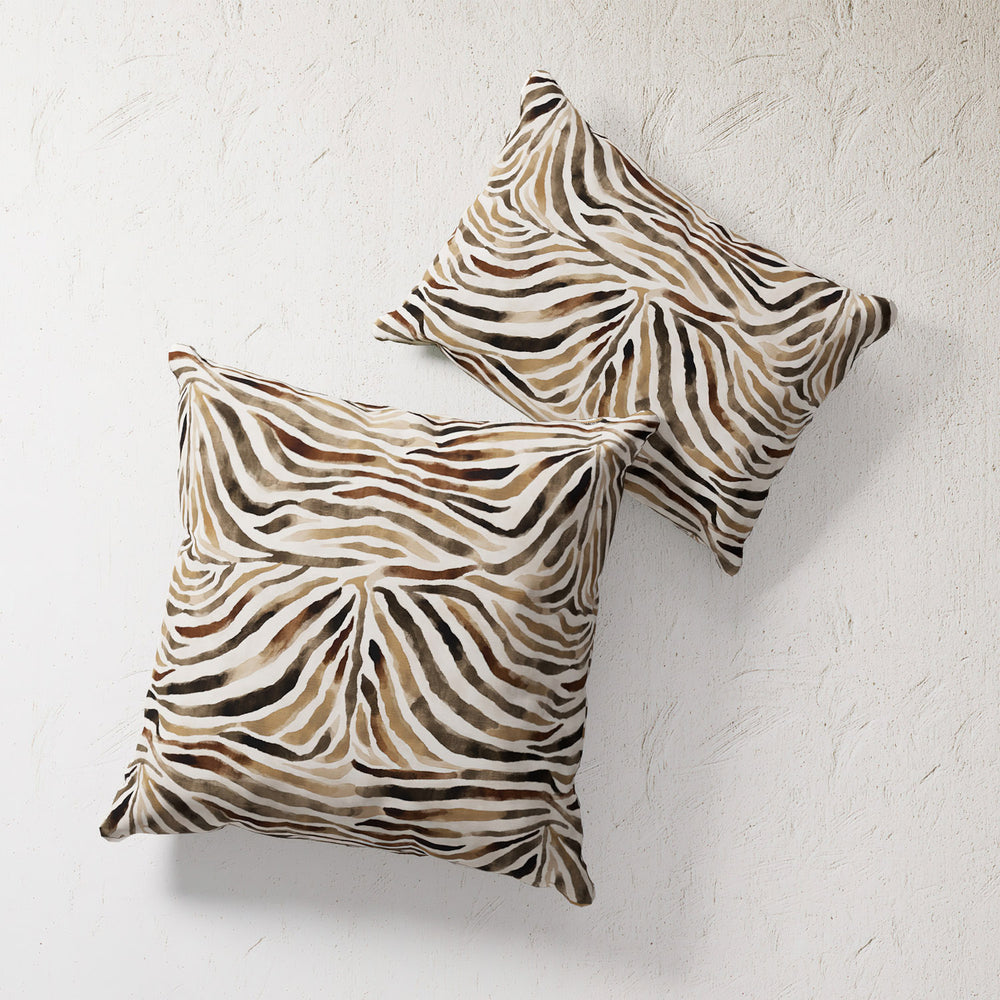 Lemieux et Cie Safari Zebra Outdoor Pillow in brown and ivory zebra stripe pattern, square pillow shown on textured plaster wall.