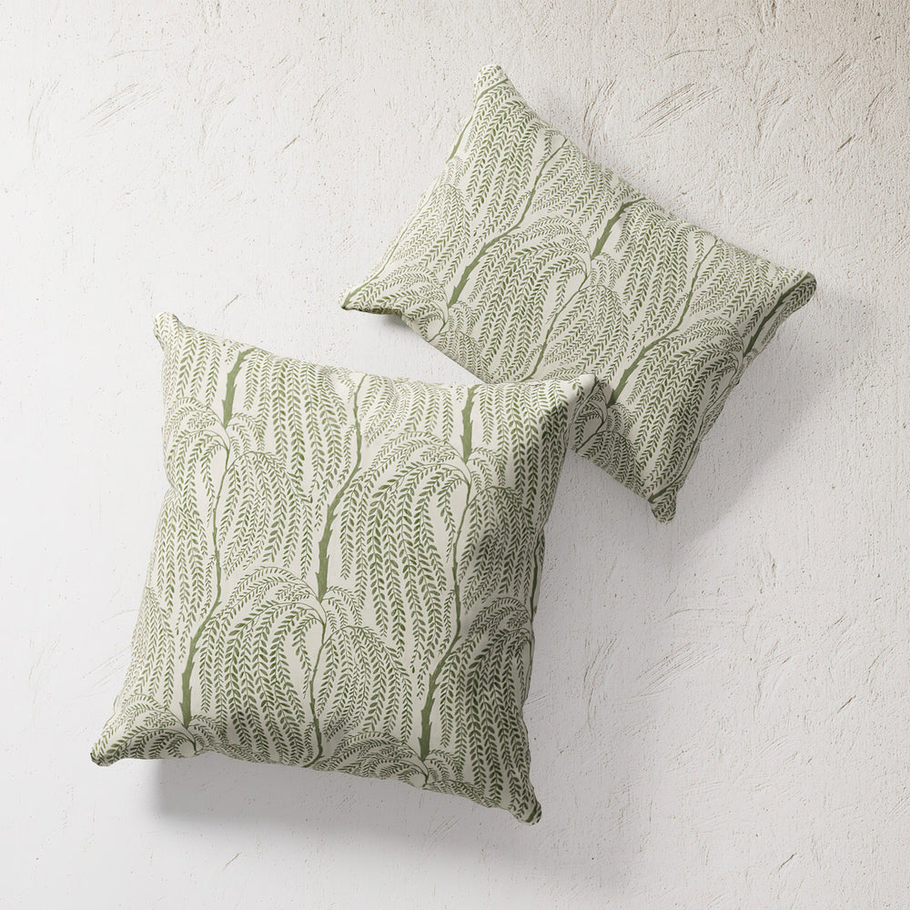 Lemieux et Cie Outdoor Pillow in Willow Trees pattern, two square pillows with green botanical print on textured plaster wall