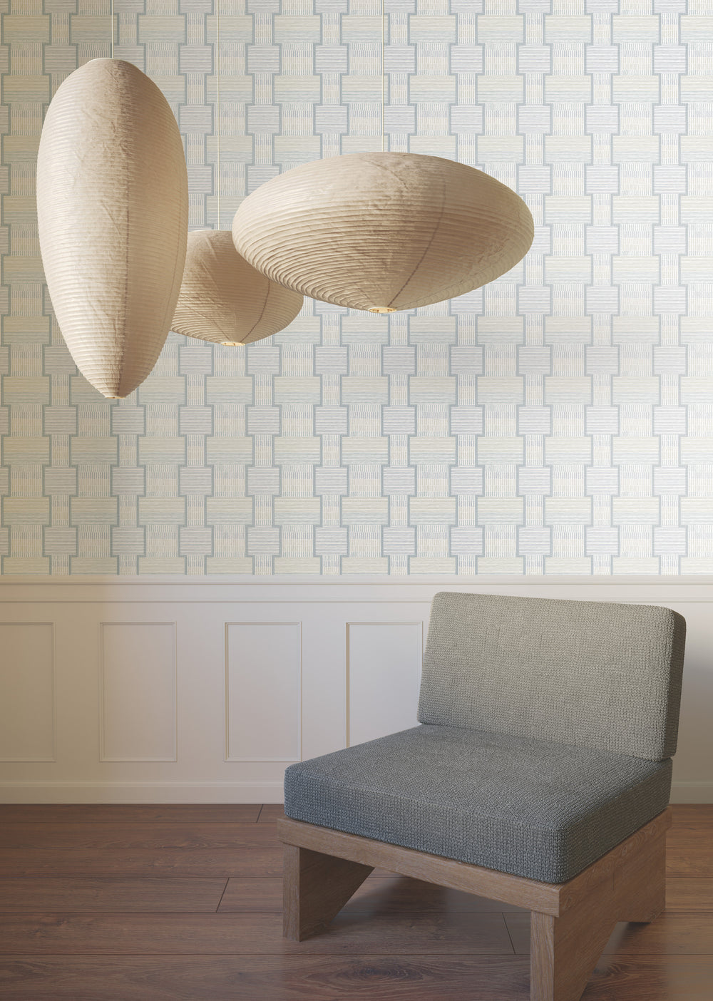 Lemieux et Cie La Broderie wallcovering in blush pink with linen beige, geometric embroidered pattern, shown with sculptural pendant lights and upholstered chair on wood floors.