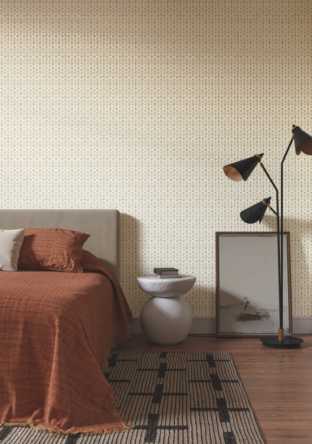 Lemieux et Cie Martigue Stripe wallpaper in sand beige with woven herringbone pattern, shown in bedroom with warm rust bedding and wood floors.