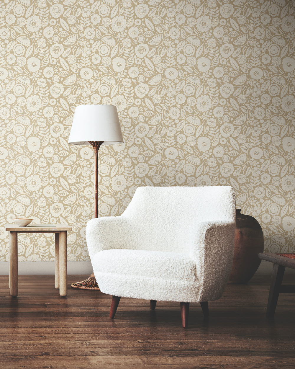 Lemieux et Cie Camelia Blossom wallpaper in vintage white and yellow ochre, floral pattern shown in sitting room with white bouclé chair and wood floors.