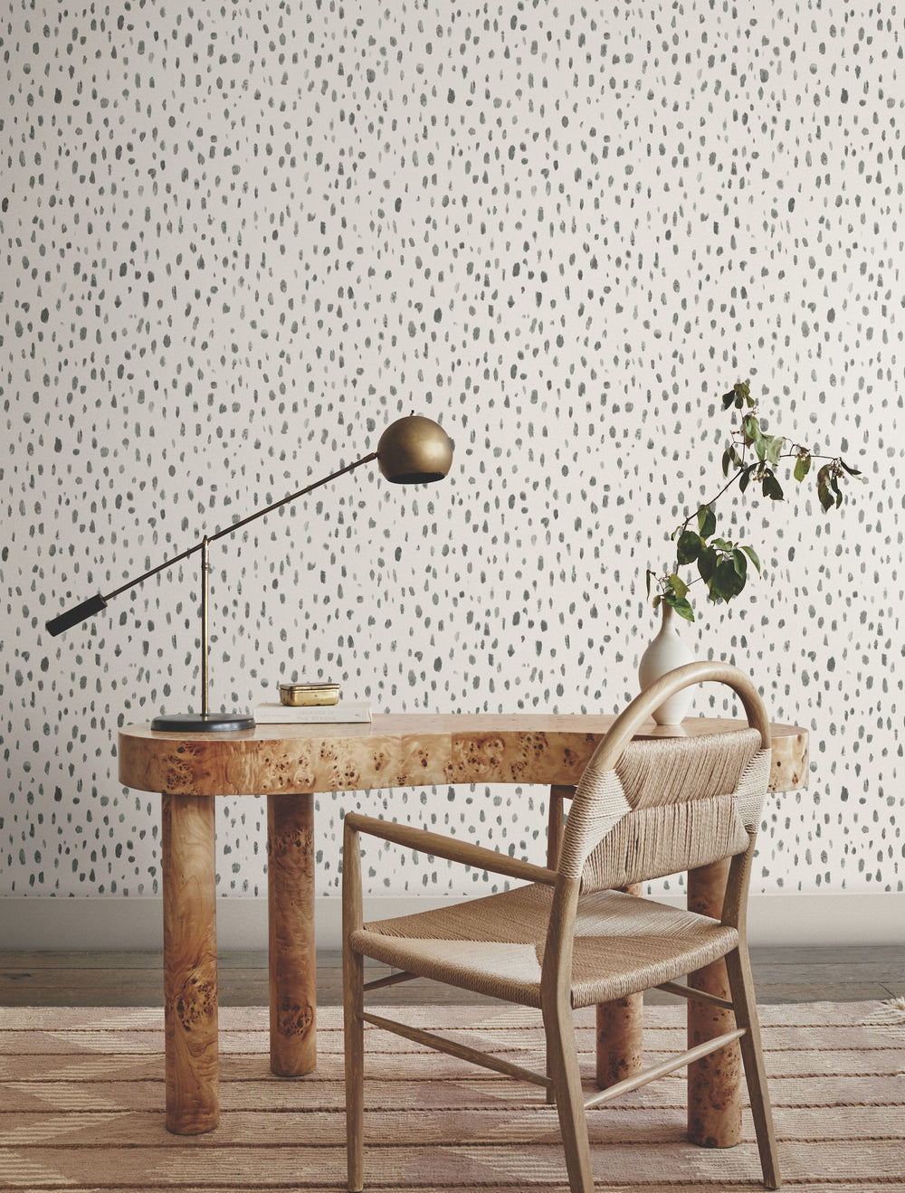 Lemieux et Cie Pluie Wallpaper in smoky blues with red and lavender, raised watercolor pattern, shown behind a burl desk and woven chair on wood flooring.