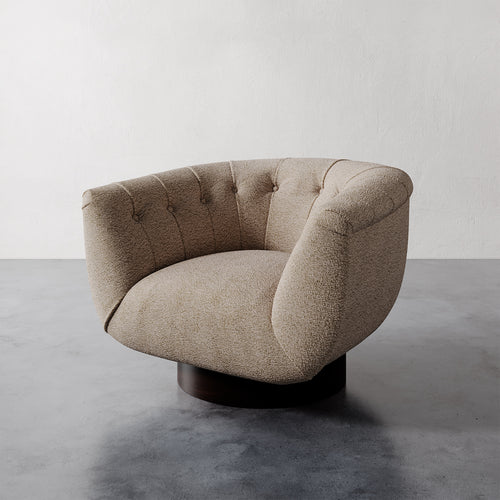 Lemieux et Cie Lune Swivel Chair in Chunky Boucle Ecru with a rounded tufted back and sculptural form set against a white wall.