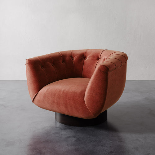 Lemieux et Cie Lune Swivel Chair in Sienna with a rounded tufted back and sculptural form set against a white wall.