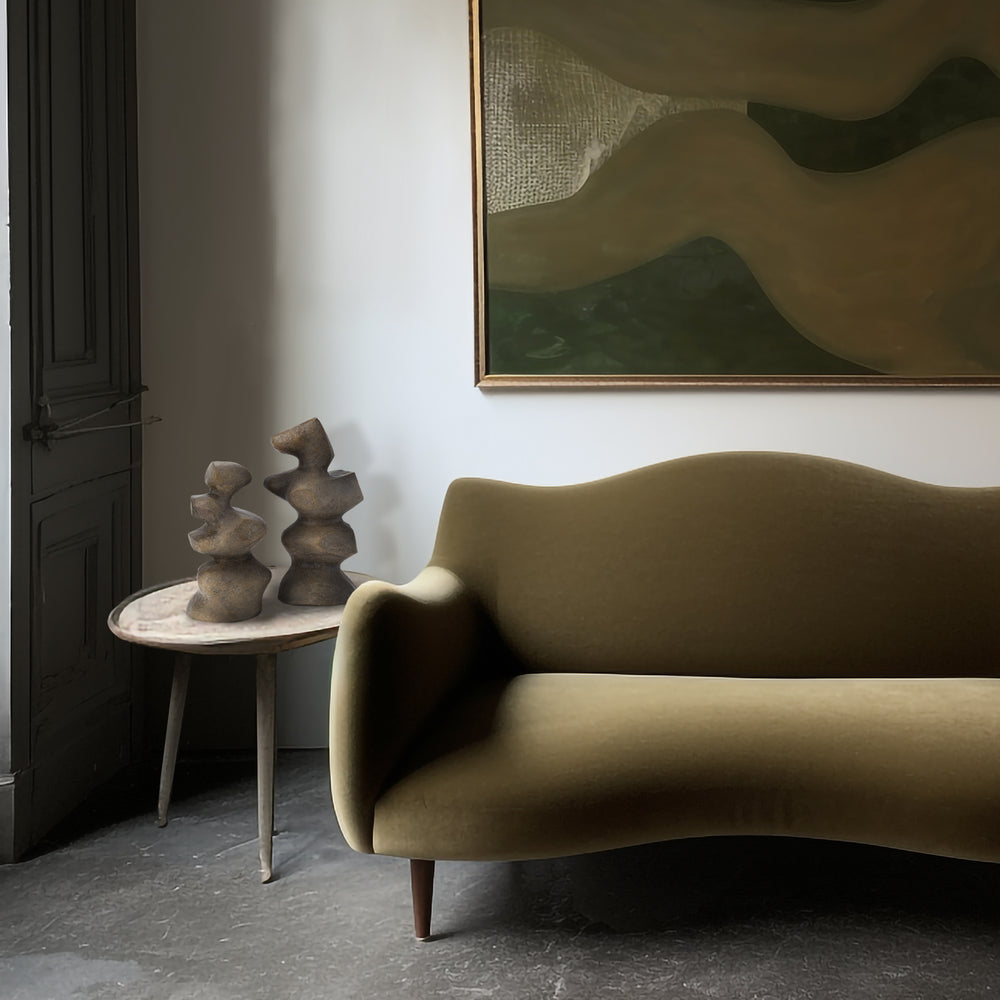 Lemieux et Cie Mguyon Sculpture pair in hand-cast aluminum with organic stacked forms, shown on marble side table beside curved sofa in room with white walls and dark wood flooring.