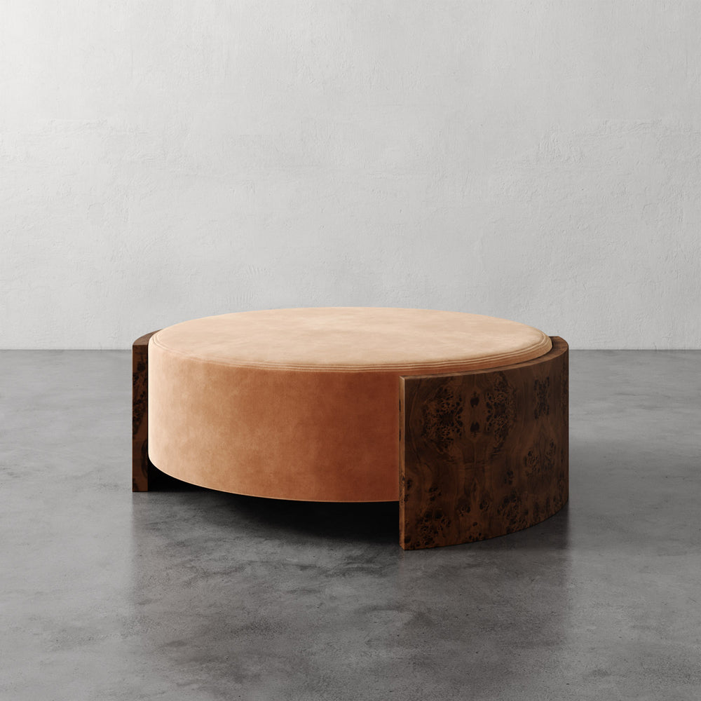 Lemieux et Cie Benoit Coffee Table Ottoman in wire brushed oak and warm leather, sculptural low-profile form on stone floor against neutral plaster wall.