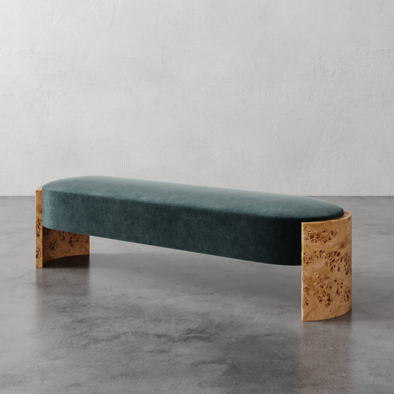 Lemieux et Cie Benoit Custom Upholstered Bench in teal velvet with Maple burl legs, low-profile bench on polished concrete floor against textured white walls.