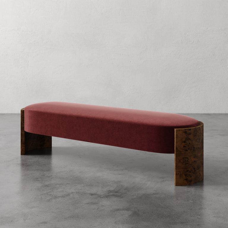 Lemieux et Cie Benoit Custom Upholstered Bench in rose velvet with curved maple burl legs, shown on polished concrete floor against white plaster wall.