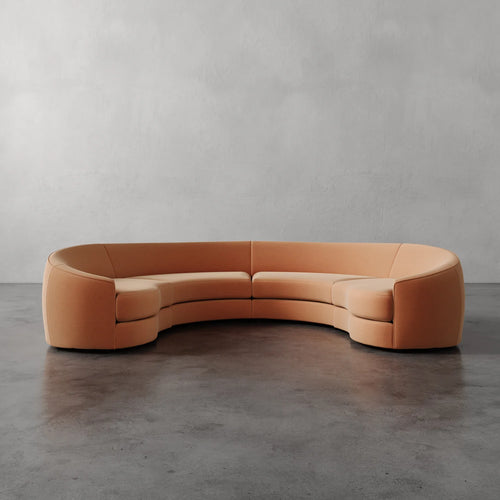 Lemieux Et Cie Rulmann 4-Piece Sectional Curved orange sofa on a gray floor with a neutral gray wall background