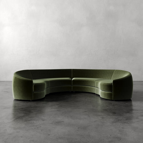 Lemieux Et Cie Rulmann 4-Piece Sectional  Green curved sofa on a gray floor with a plain gray wall background