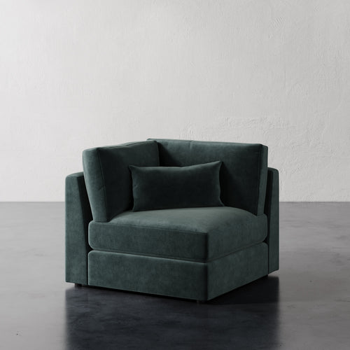 Lemieux Et Cie Lacroix Corner Chair Dark Teal velvet chair against a plain white wall.