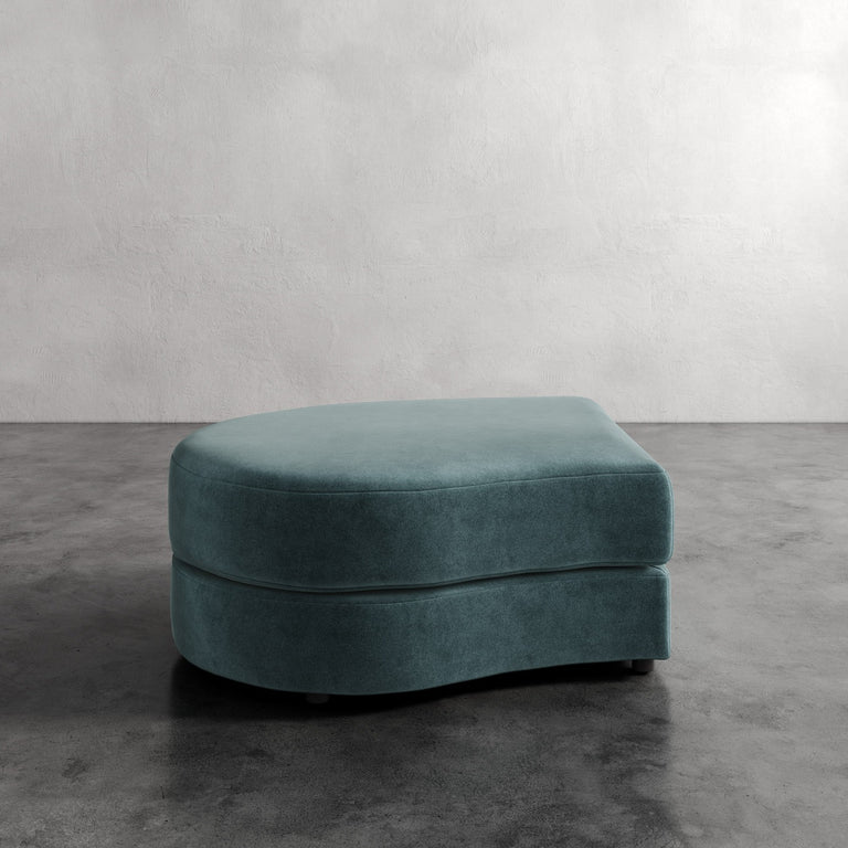 Lemieux Et Cie Rulmann Left Ottoman
 Teal ottoman on a gray floor with a neutral background