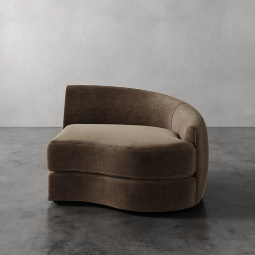 Lemieux Et Cie Rulmann Right Arm Chair Brown curved sofa against a gray wall on a gray floor