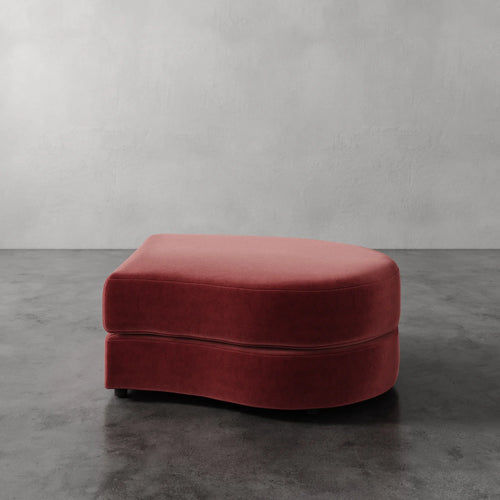 Lemieux Et Cie Rulmann Right Ottoman Red ottoman on a gray floor with a plain wall background