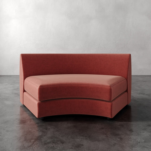 Lemieux Et Cie Rulmann Wedge Red curved sofa against a plain wall