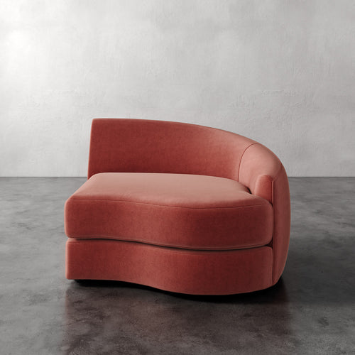 Lemieux Et Cie Rulmann Right Arm Chair Pink curved sofa on a gray floor with a white wall background