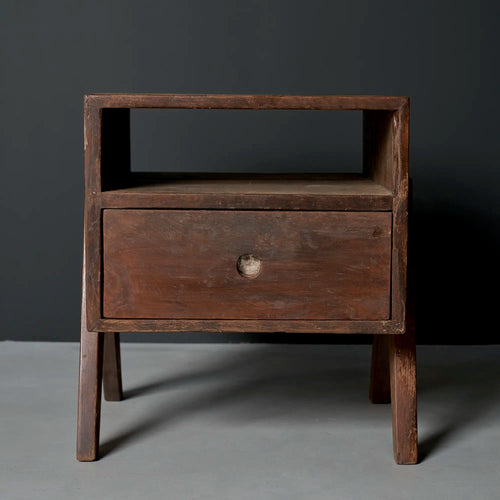 Lemieux et Cie Pierre Jeanneret bedside table in solid teak - front view of a single table with an open shelf above a single drawer and a circular cutout pull, on outward-splayed legs