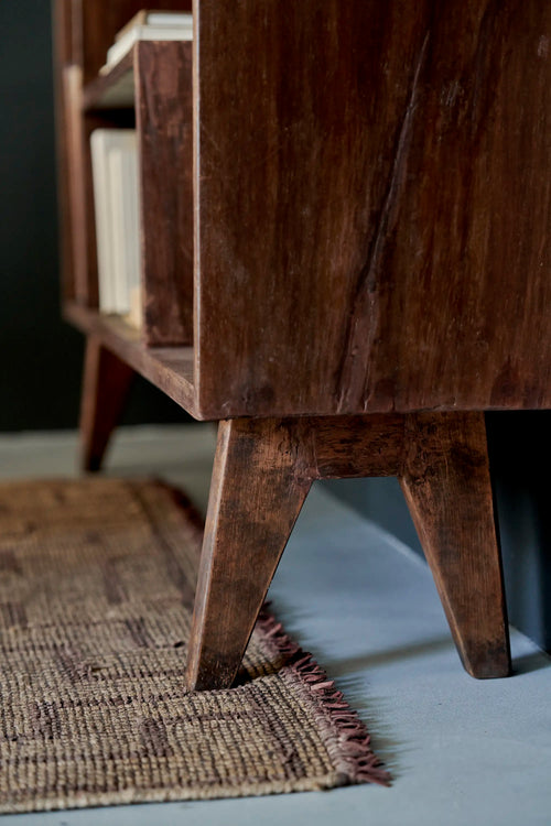 Lemieux et Cie Pierre Jeanneret bookcase in solid teak - styled three-quarter view of the open shelves with books and ceramics on top