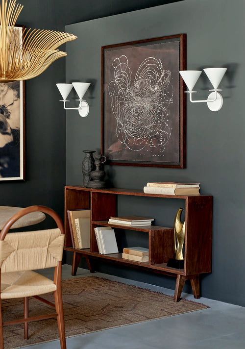 Lemieux et Cie Pierre Jeanneret bookcase in solid teak, High Court of Chandigarh, Capitol Complex, 1962 - styled in a room with wall sconces and framed art, showing the asymmetrical body with a full-height open bay at left and stepped open shelves at right on four tapered splayed legs