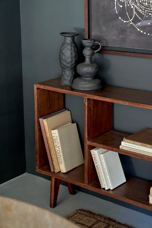Lemieux et Cie Pierre Jeanneret bookcase in solid teak - styled three-quarter view of the open shelves with books and ceramics on top