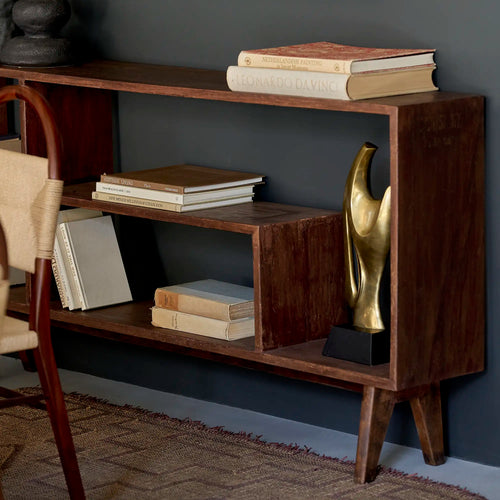 Lemieux et Cie Pierre Jeanneret bookcase in solid teak - styled three-quarter view of the open shelves with books and ceramics on top