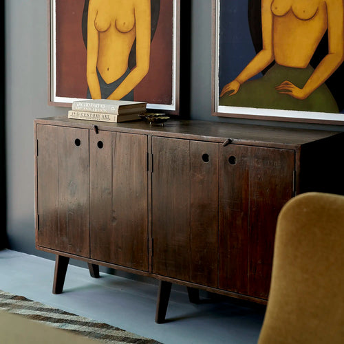 Lemieux et Cie Pierre Jeanneret four-door teak cabinet from Chandigarh, styled beneath framed nude portraits - square format