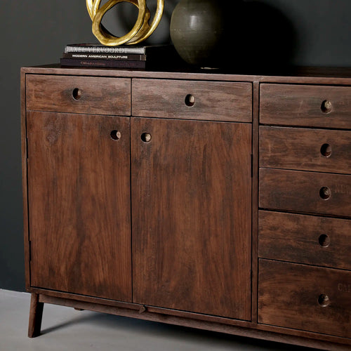 Lemieux et Cie Pierre Jeanneret library storage cabinet in solid teak - styled three-quarter view with a brass sculpture and ceramic objects on top