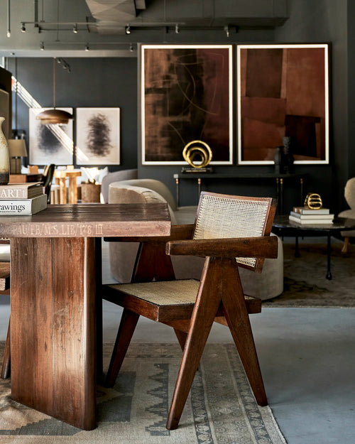 Lemieux et Cie Pierre Jeanneret library table in solid teak - three-quarter view styled with a chair and framed art