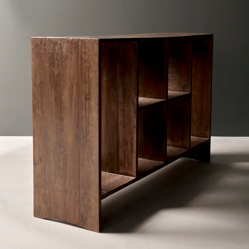 Lemieux et Cie Pierre Jeanneret low bookcase in solid teak - three-quarter view showing the side-panel leg, the open compartments and the low plinth base