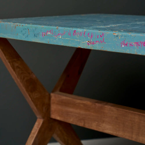 Lemieux et Cie Pierre Jeanneret X-leg student desk with original blue painted top - three-quarter view of the blue painted top with student inscriptions and the X-leg base