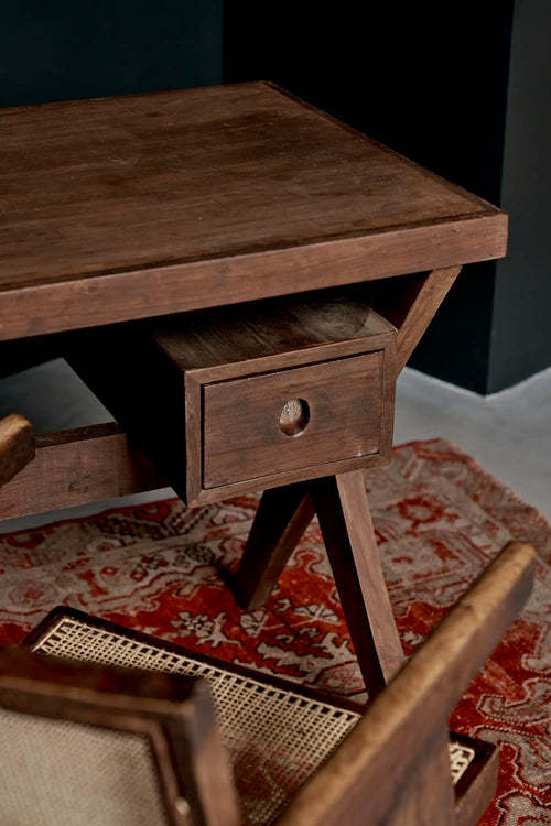 Lemieux et Cie Pierre Jeanneret writing desk in solid teak - styled three-quarter view with the drawer, X-legs and a teak armchair