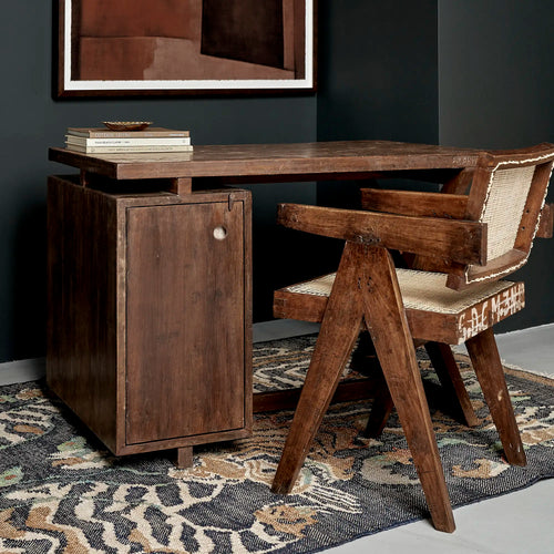 Lemieux et Cie Pierre Jeanneret writing desk in solid teak - styled three-quarter view from the door side with a teak armchair