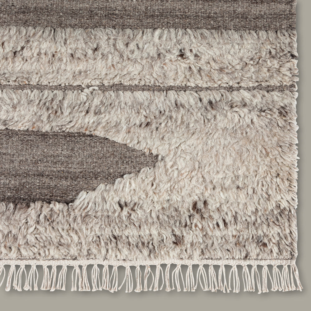 Lemieux et Cie Rafalla Rug in natural undyed wool with high-low geometric stripe pattern, handmade rug detail showing textured pile and knotted fringe on neutral backdrop.