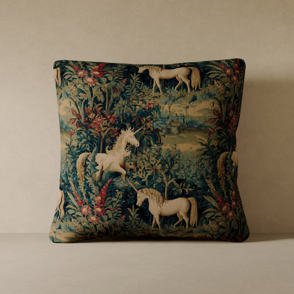 Lemieux et Cie Unicorn Velvet Pillow in teal and ivory tapestry-style pattern, performance velvet cover with horses and florals, against warm plaster wall.