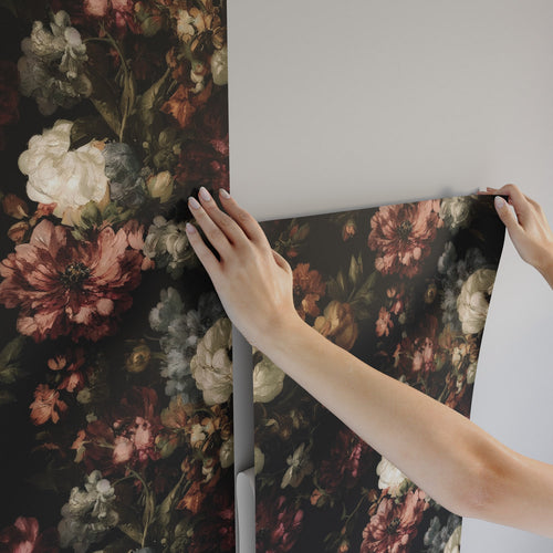 Lemieux et Cie Renaissance Floral peel and stick moody wallpaper with painterly blooms in warm rust, blush, and ivory emerging from a deep black ground, ideal for dining rooms and powder rooms.