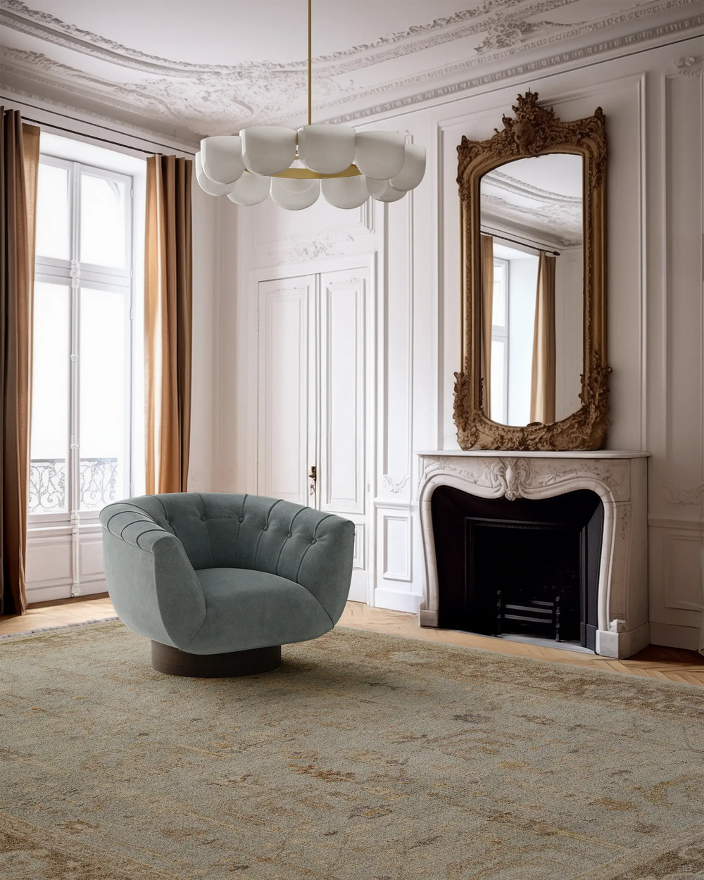 Lemieux et Cie Lafleur Serein Handmade Wool Rug in muted sage and gold tones, shown beneath rounded sage chair in Parisian sitting room with ornate molding and fireplace