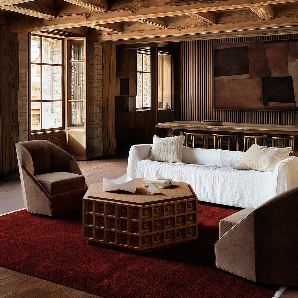 Lemieux et Cie Dubois Hexagonal Coffee Table, geometric coffered form, styled in sitting room with wood beam ceiling, stone walls, red carpet, and wood floors.