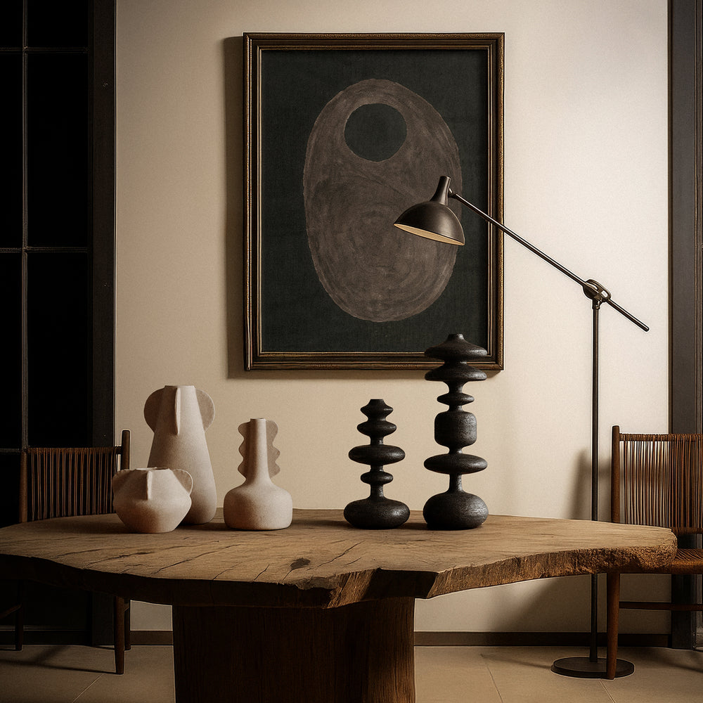Lemieux et Cie Romain Totems, sculptural stacked forms in dark textured finish, displayed on wood table with floor lamp and framed art on neutral walls.