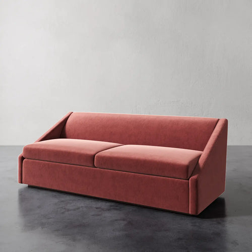 Lemieux et Cie Fontaine Sofa in terracotta upholstery, architectural two-cushion sofa on dark concrete floor against textured plaster walls.
