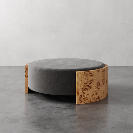 Lemieux et Cie Benoit Coffee Table Ottoman in charcoal upholstery with wire-brushed oak panels, low-profile ottoman shown on gray concrete floor.