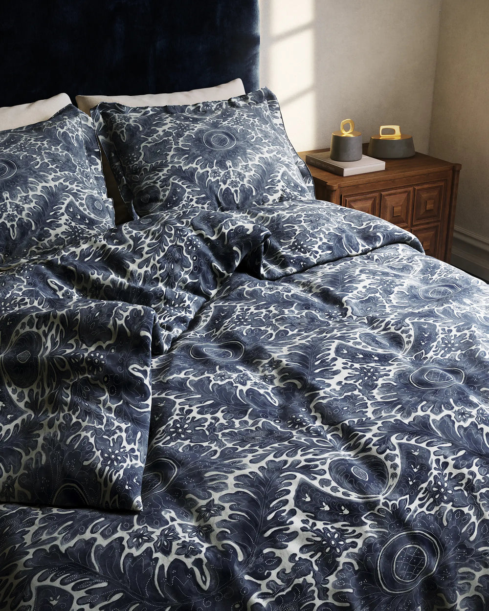 Lemieux et Cie Toile de Rouen percale duvet and matching shams styled with pillows on wood nightstand in soft daylight.