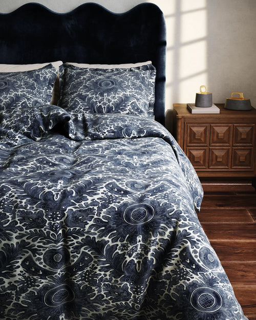 Lemieux et Cie Toile de Rouen percale duvet cover in indigo and ivory, shown on the Celine bed with scalloped headboard in warm-lit bedroom with wood floors and voltaire nightstand.